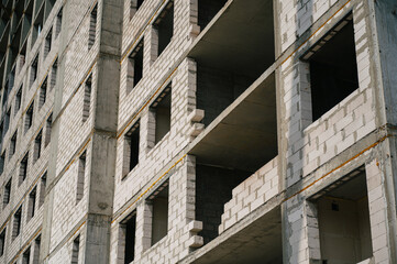 Concrete building under construction with exposed brickwork and empty windows