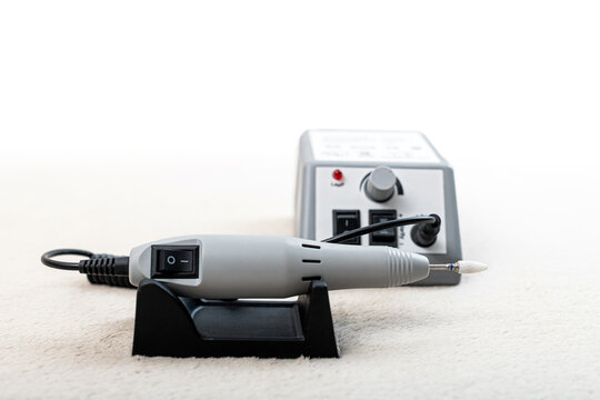 Electric nail drill machine and a control unit on a white background. Manicure pedicure equipment for studio.