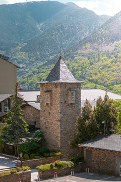 Tower of historic Casa de la Vall building in Andorra la Vella Old Town with Pyrenees mountains in the background on a sunny day