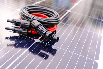 Solar cables connect solar panel to home for renewable energy use with black and red wires