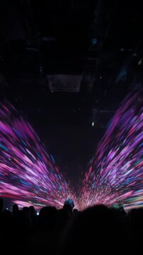 Colorful lights flashing in a dark room with people