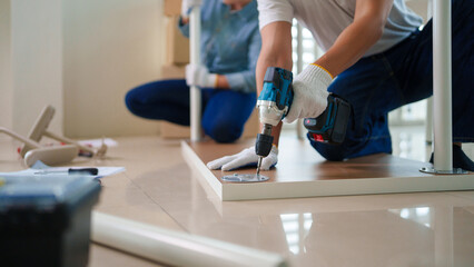 Asian adult couple assembly furniture new home apartment teamwork project DIY setup interior improvement planning together modern living space