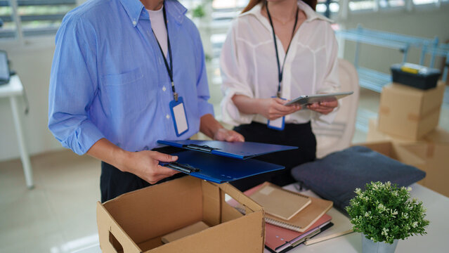 Asian adult professionals managing office relocation process planning teamwork organizing documents at new workspace business employees moving company office setup coordination