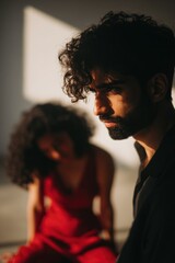 Pensive young adult couple in soft light with intense shadows