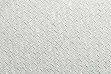 White woven material with a textured pattern showing a detailed design and uniformity in the structure across the surface