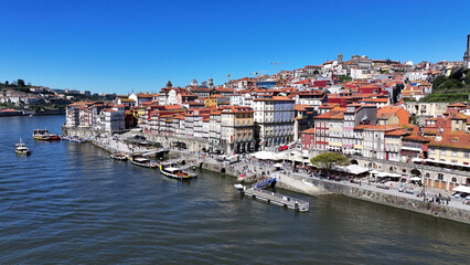 Obraz premium Ribeira Pier In Porto Portugal. Turquoise Ocean Waves Gently Crashing On Tropical Beach. Metropole Landscape Company Building Vibrant. Metropole Corporate Town. Porto Portugal.