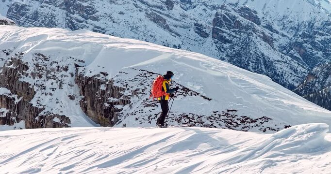 Aerial footage of a ski mountaineer in a snowy alpine ridge in Dolomites. Winter landscape, backcountry adventure, and solitude in breathtaking mountain scenery captured in 4K.