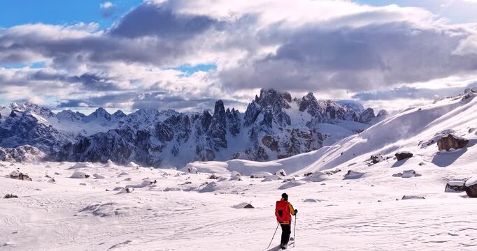 Aerial footage of a ski mountaineer in a snowy alpine ridge in Dolomites. Winter landscape, backcountry adventure, and solitude in breathtaking mountain scenery captured in 4K.