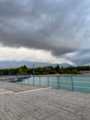 Fototapeta premium Pier at Issyk Kul Lake in Kyrgyzstan. Calm water surface, minimal composition and warm sunset light.