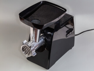 Household electric table meat grinder on a gray background