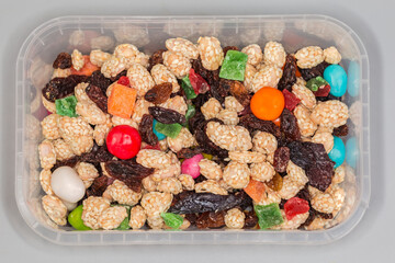Nuts, dried fruits, candied fruits in open container, top view