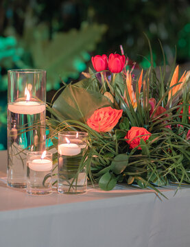 Elegant Wedding Table Centerpiece with Floating Candles and Tropical Flowers