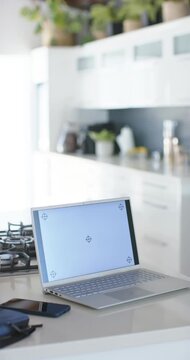 Vertical video: Camera is moving forward and tilting to frame laptop with target screen on island