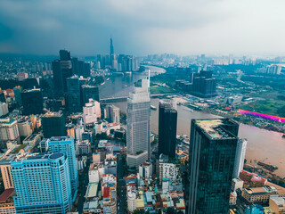 sunset over modern Ho Chi Minh city skyline and Saigon river, financial downtown district with high-rise skyscraper towers, Hochiminh Vietnam aerial drone view 4k
