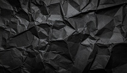 Crumpled black paper texture creating abstract dark background