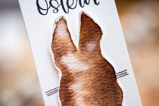 Anh&auml;nger / Lesezeichen aus Kraftpapier mit einem handgemalten Hasen Osterhase mit Aquarell in verschiedenen Farben.
