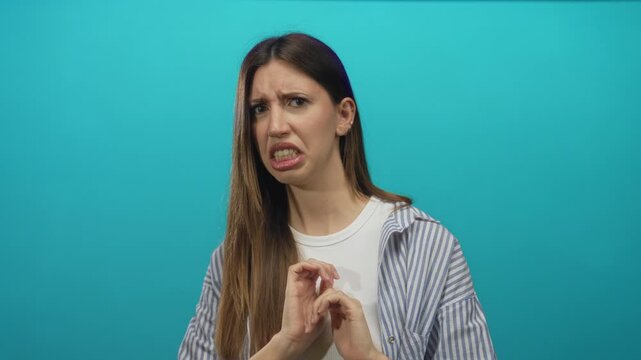 Young hispanic woman wearing striped shirt and white top showing palms in studio; disgust revulsion repulsion aversion.