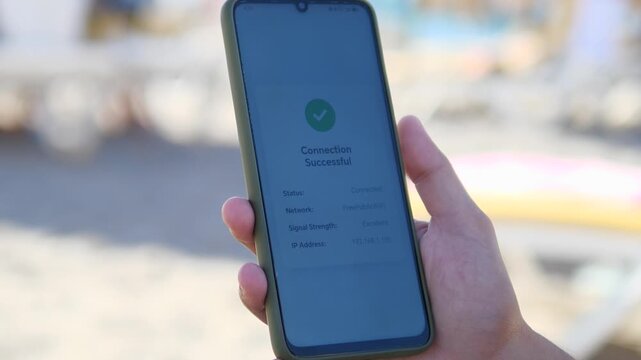 Close-up of smartphone screen showing Connection Successful to free public Wi-Fi at a beach resort. Perfect for digital nomad lifestyle, remote work, travel technology, and summer vacation