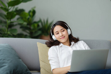 Woman enjoys music and work on laptop in cozy indoor setting