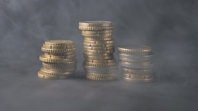 coin arranged in row and surrounded by drifting smoke. Dramatic atmosphere symbolizing financial crisis, inflation, economic uncertainty, loss, or market volatility. Conceptual business background
