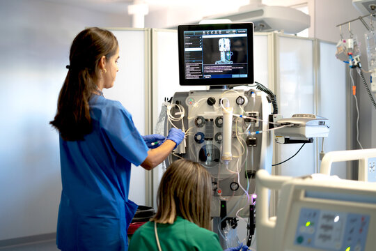 Medical team preparing dialysis equipment in a hospital setting