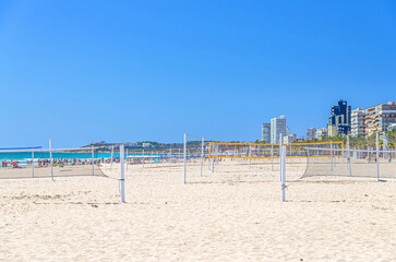 Playa de San Juan beach in Alicante city, sports volleyball courts with volleyball net on sandy beach of Mediterranean Sea coast Costa Blanca coastline in sunny summer day, Valencian Community, Spain
