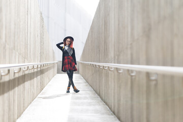 Young woman posing in modern concrete architectural space