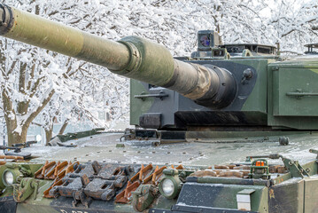 Close-up of a Leopard 2A4 main battle tank turret and 120mm smoothbore gun. Heavy armored military vehicle in snowy winter conditions. © Amateur007