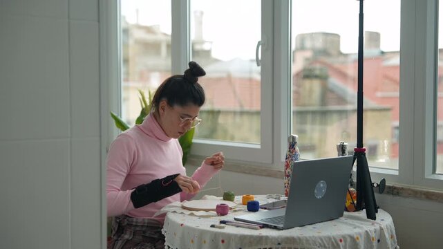 Woman systematically sorting yarns and filming accessories on table