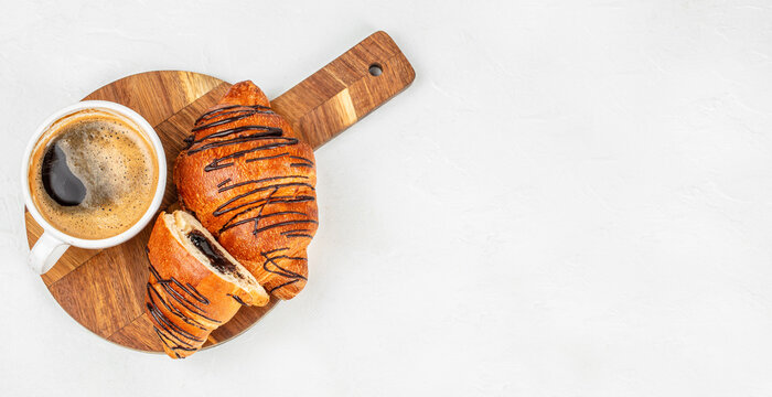 Chocolate croissants with coffee on wooden board isolated on white background