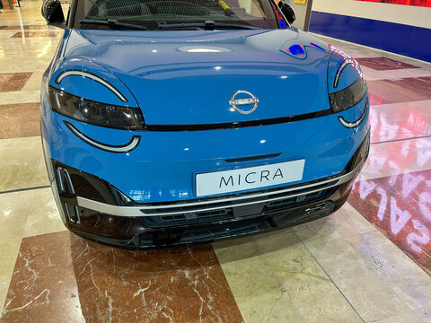 Pamplona, ​​Spain - February 23, 2026. A blue compact car, Nissan Micra model, displayed inside a dealership, with modern design, circular lights and details in glossy black.