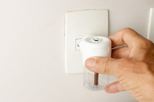 Man Plugging in An Electric Plug in Mosquito Repellent for home use