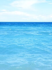 Fototapeta premium vertical view of a calm light blue sea in Greece with white clouds
