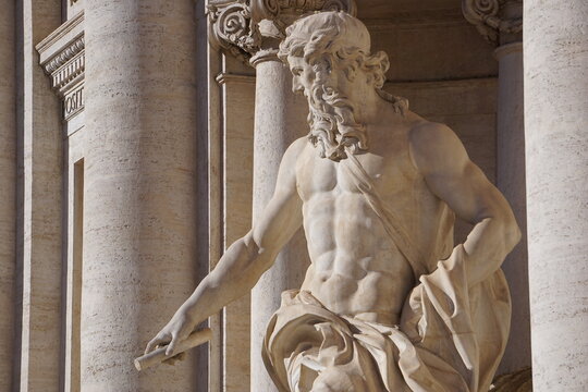 Side profile close up of the monumental statue of the mythological titan Oceanus among the baroque columns of Trevi Fountain (Fontana di Trevi), Rome, Italy