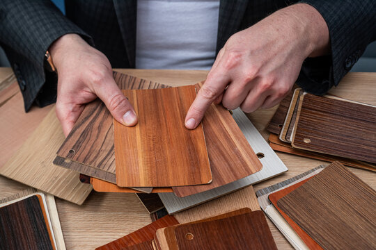 Interior Designer Choosing Wood Texture Samples and Laminate Swatches for Furniture Production