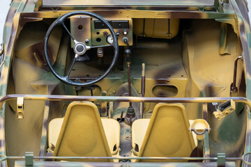 Interior of a camouflage-colored veteran German Kubelwagen military off-road vehicle