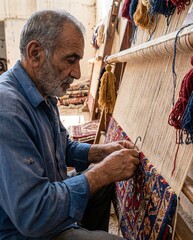 Obraz premium Skilled artisan weaving a traditional carpet with intricate patterns in workshop