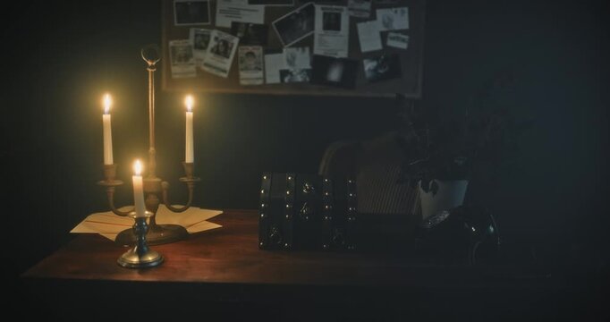 Lightning flashing in spooking office room with glowing candles and mysterious small chest - dolly in