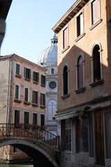 Obraz premium Venetian canal with historic buildings and traditional architecture in Venice, Italy. Scenic waterfront view with reflections and classic European city atmosphere. Iconic travel destination in Souther
