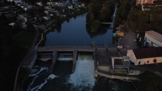 Drohnenaufnahme von Baden in der Schweiz mit Flusslauf, Wasserkraftwerk und Stadtlandschaft
