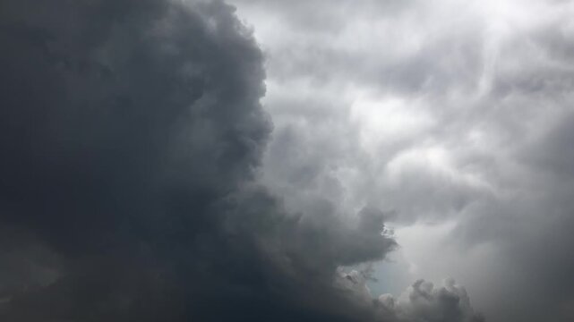 Dark storm clouds race across the sky in timelapse, building a dramatic weather front. Gloomy thunderheads sweep overhead as fast motion reveals shifting overcast layers before rain.