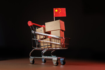 Chinese goods packed in boxes stacked on shopping cart with Chinese flag