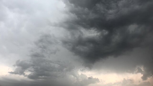 Time lapse video of mixed variable weather as storm clouds dissipate in the sky after rain. Soft sunlight breaks through misty air, revealing calm atmosphere. Hatay Dortyol Turkey.