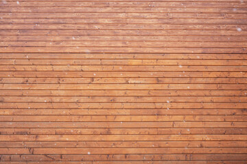 Fototapeta premium Horizontal wooden planks forming a rustic wall texture background with falling snow