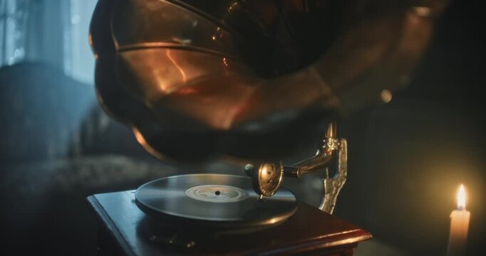 Glowing gramophone horn and spinning disc in dark room - closeup shot
