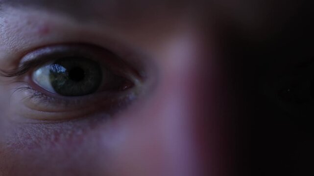 Spends whole nights gaming eyes tired yet focused pupils reflecting bright screen deep immersion into virtual world and loss of sense of time