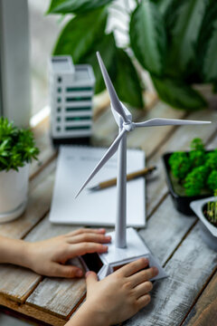 Primary school scientific environmental project. Concept of ecology lessons, ecological awareness of children. Little kid making design of future city with renewable energy, wind turbine, green spaces