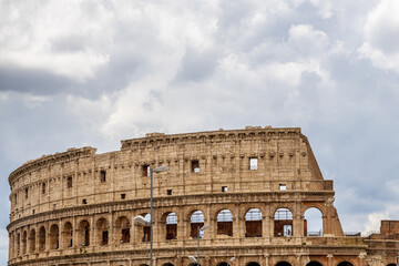 Fototapeta premium Famous tourist attraction of historic Colosseum amphitheatre with ancient stone arches in Rome Italy