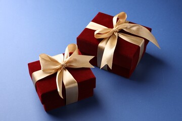 Obraz premium Beautiful velvet gift boxes on blue background, closeup
