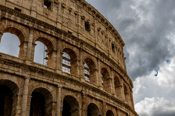 Fototapeta premium Famous tourist attraction of historic Colosseum amphitheatre with ancient stone arches in Rome Italy